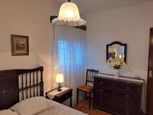 a bedroom with a bed and a dresser and a mirror at Casa da Miquinhas I in Ponte da Barca