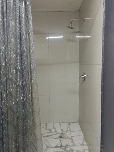 a bathroom with a shower with a shower curtain at Camp Inn Lodge in Pietermaritzburg