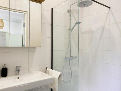 a white bathroom with a shower and a sink at Modern Studio 1 in Historic Abbey in Cadier en Keer