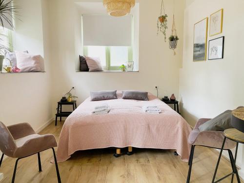 a bedroom with a bed with a pink blanket at Modern Studio 1 in Historic Abbey in Cadier en Keer