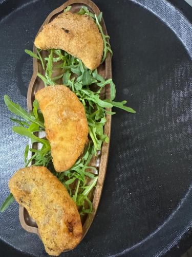 a wooden plate with a sandwich with greens on it at Antico Mulino Hotel Garni in Todtmoos
