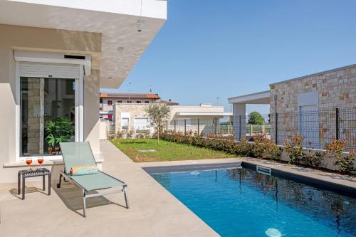 a patio with a chair and a swimming pool at Villa Milvia in Colà di Lazise