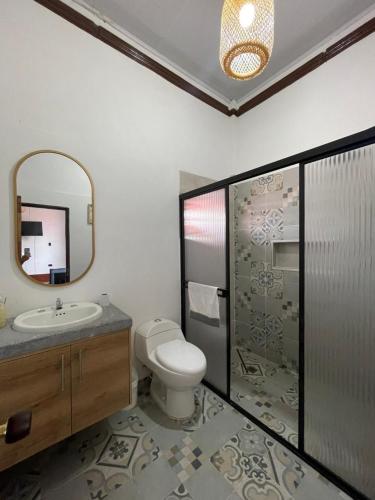 a bathroom with a toilet and a sink and a mirror at Casona El Remanso in Mariquita