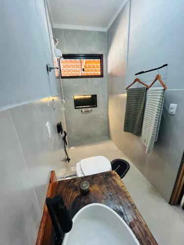 a bathroom with a toilet and a sink at Pouso Canastra - Chalés in São João Batista do Glória