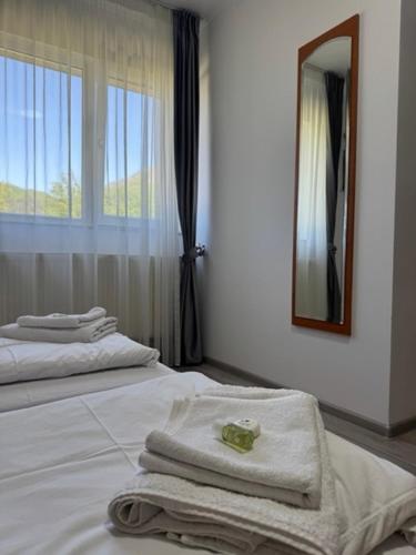 a bedroom with two beds with towels and a mirror at Motel Vatra Bunătăților in Brezoi