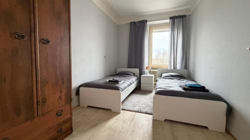a bedroom with two beds and a window at Leo, apartment in Wasserbillig