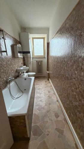 a bathroom with a sink and a tub and a window at Leo, apartment in Wasserbillig