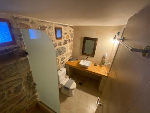 ein Badezimmer mit weißer Toilette und Waschbecken in der Unterkunft Castle Rizaraki in Kokkala