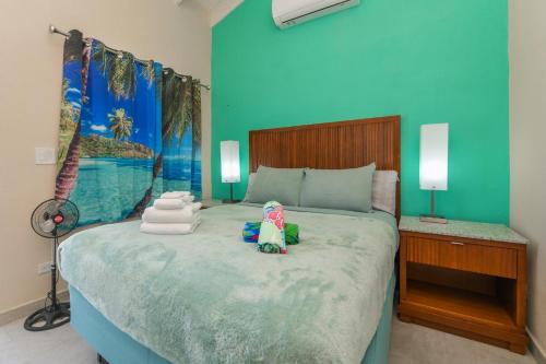 a bedroom with a large bed with a blue wall at Atupa House in Noord