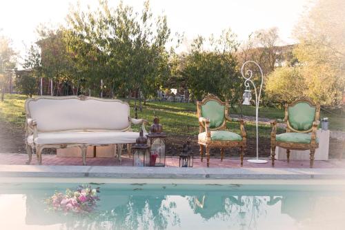 um par de cadeiras sentadas ao lado de uma piscina em La Locanda di Borghetto em La Giustiniana