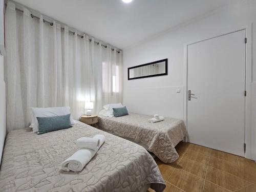 a bedroom with two beds with towels on them at SHR House in Porto Formoso
