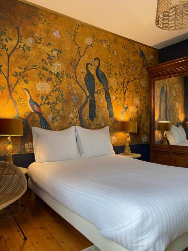 a bedroom with a large bed and a wall mural at La TULIPE SAUVAGE in Bourdeaux