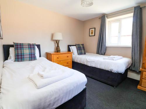 a bedroom with two beds and a window at Clwyd Cottage in St Asaph