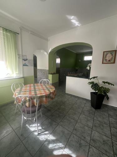 a dining room with a table and chairs in a room at Viktor Apartmanház in Zamárdi