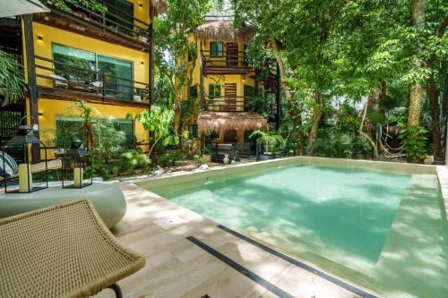 a swimming pool in front of a building with trees at Terasu Riviera Maya Hotel & Spa, en Xcaret in Playa del Carmen