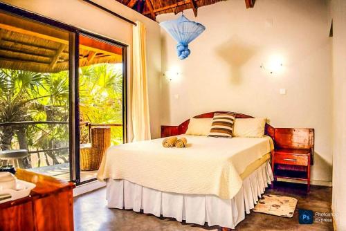 a bedroom with a bed with two teddy bears on it at Lagoon Bay Chidenguele in Chidenguele