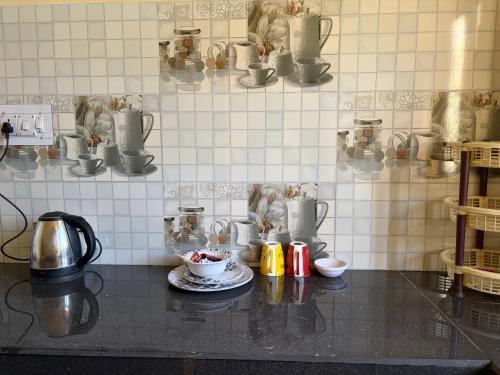 a kitchen with a counter top with a cup of coffee at Aangan by Mom in Kalpa