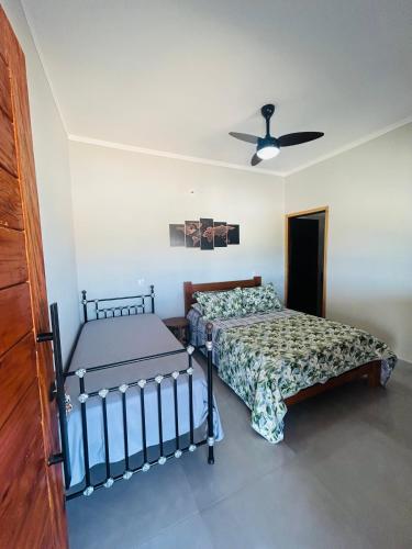 a bedroom with two beds and a ceiling fan at Pouso Canastra - Chalés in São João Batista do Glória