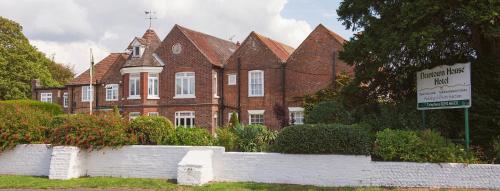 a large brick house with a sign in front of it at Newtown House Hotel in South Hayling