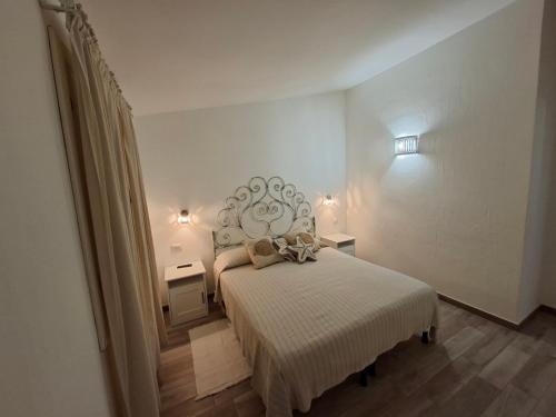 a bedroom with a white bed with a head board at Residence Porto Rotondo in Porto Rotondo