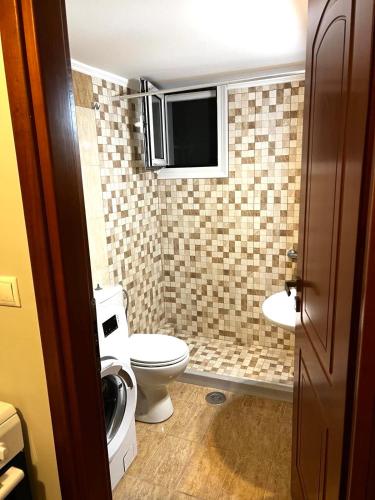 a small bathroom with a toilet and a sink at Katies cozy corner in Chios