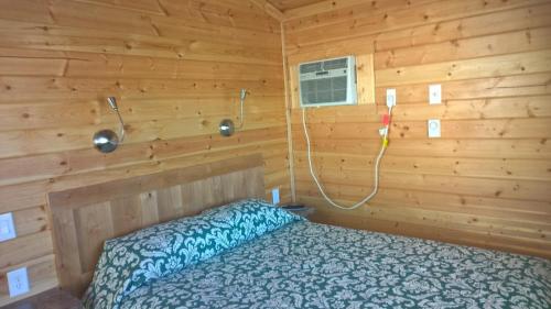 a bedroom with a bed in a wooden cabin at Lake Minden Camping Resort Cottage 1 in Nicolaus
