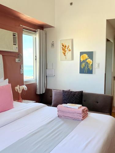 a bedroom with two beds and a window at Sunvida Tower Corner Suite Across SM Cebu in Cebu City