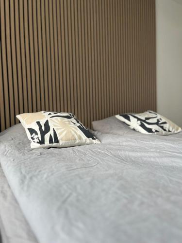 a bed with two pillows on top of it at Seminaari Hill Suite in Jyväskylä