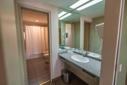 a bathroom with a sink and a large mirror at Comodoro Hotel in Comodoro Rivadavia
