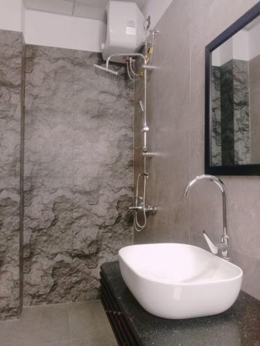 a white sink in a bathroom with a stone wall at Falcon View in Nuwara Eliya
