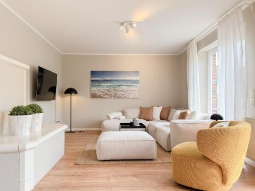 a living room with a white couch and chairs at Seebär in Scharbeutz