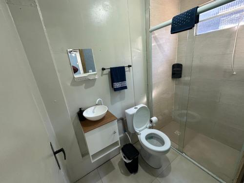 a bathroom with a toilet and a sink and a shower at Casa Container Completa e Privativa em Sombrio-SC in Sombrio