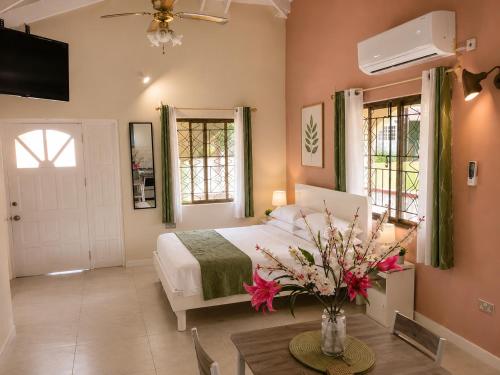 a bedroom with a bed and a table with flowers on it at Paradise Inn in Laborie
