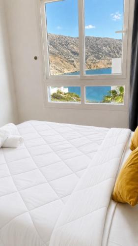 a white bed in a room with a window at Padova Surf Hous in Imsouane