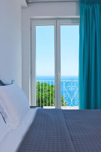 a bedroom with a bed and a view of the ocean at Don Felipe Boutique Hotel in Ischia Town