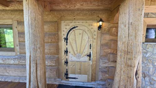 an entrance door to a log cabin with columns at Sarnia CHATA in Brenna