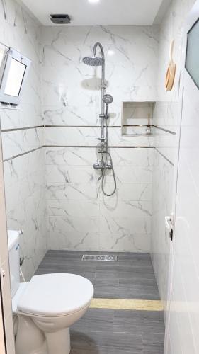 a white bathroom with a shower and a toilet at Padova Surf Hous in Imsouane