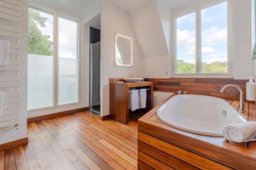 a large bathroom with a large tub and windows at Domaine De La Corniche in Rolleboise