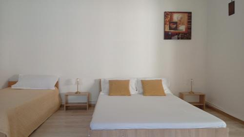 two beds in a room with white walls at Casa Carmen in Târgu Ocna