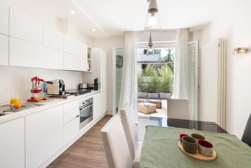 a kitchen with white cabinets and a table with a plate on it at The Iconic Ceccarini - Riviera Collection in Riccione