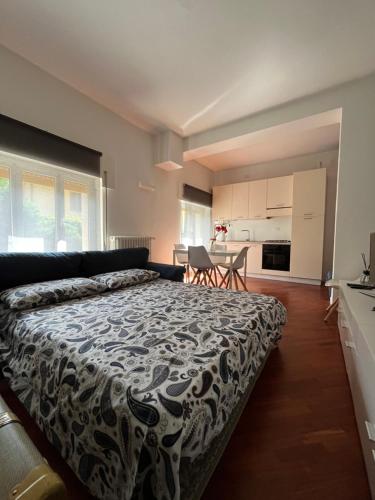 a bedroom with a large bed and a kitchen at Maison de l'Eau by Lago Maggiore Rentals in Verbania