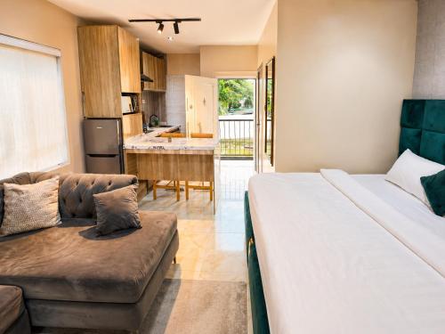 a bedroom with a bed and a couch and a kitchen at Happy Lodge Shortlets & Suites, Freedom Way, Lekki phase 1 in Ogoyo