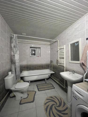 a bathroom with a tub and a toilet and a sink at Bugu Too Guest House in Kaindy