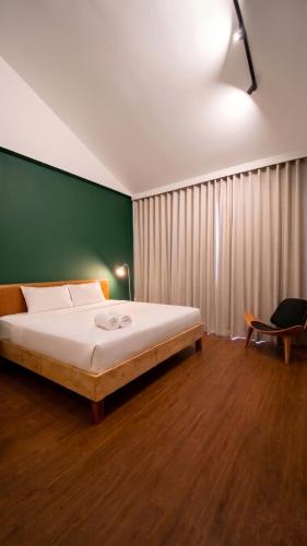 a bedroom with a bed and a green wall at Centerpoint Koh Phangan New in Thong Sala