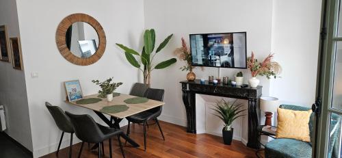 a dining room with a table and a mirror at Les balcons de Dieppe - appartement 1ER étage - certifié 3 étoiles au cœur de la rue piétonne in Dieppe