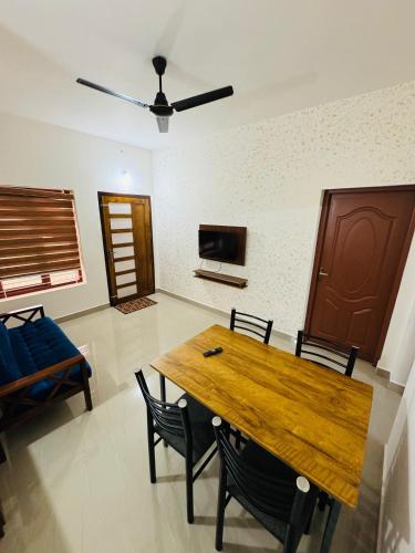 a dining room with a wooden table and chairs at Iconic villas by ROYAL VILLAS in Athirappilly