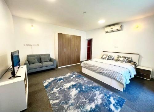 a bedroom with a bed and a couch and a television at Labella Chalet in Barka
