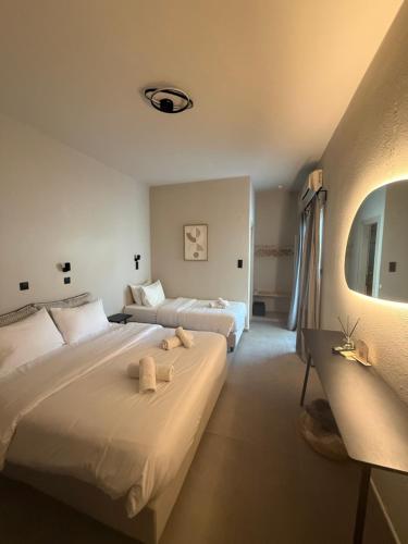 two beds in a hotel room with towels on them at Mellow Paros in Parikia