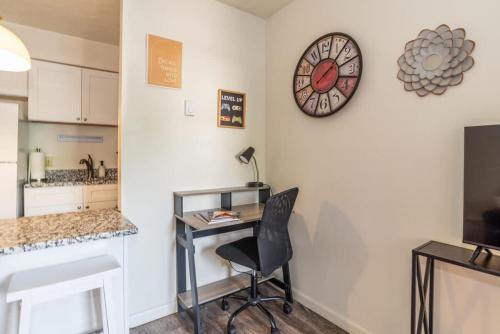 a room with a desk and a clock on the wall at Karma Vibe Like That in Bloomington