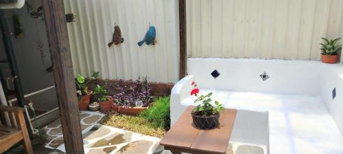 a porch with a bench with a table and plants at Casa Campana in Concepción de Ataco